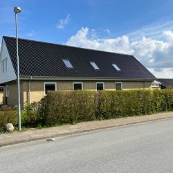 sort tag på gul bygning
