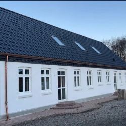 Tagarbejde med sort tag på hvidt hus