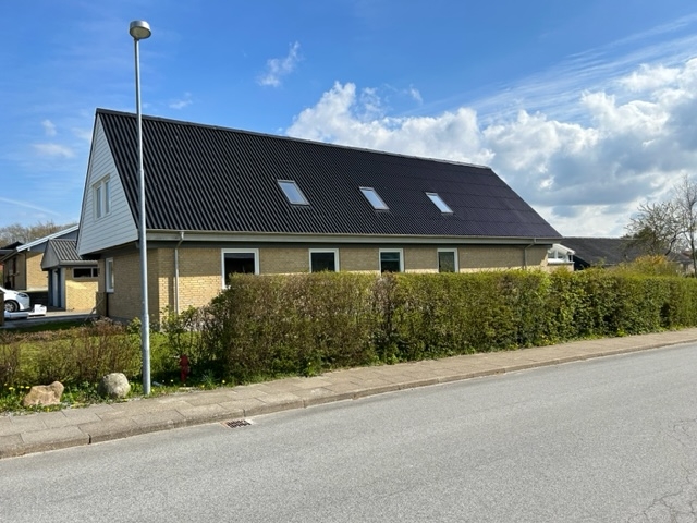 sort tag på gul bygning