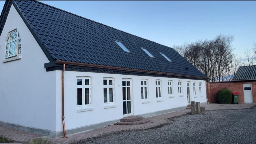 Tagarbejde med sort tag på hvidt hus